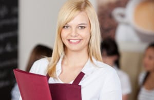 Confident Cafe Waitresses Holding Menu In Cafe